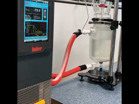 Reator de vidro encamisado com controle de temperatura digital e chiller de alta precisão da marca Huber em um ambiente laboratorial moderno.